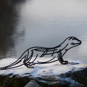 Watchful otter Wildlife Sculpture standing beside a river